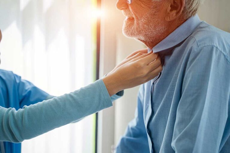 Older adult and family member review an assisted living fee agreement at a kitchen table.